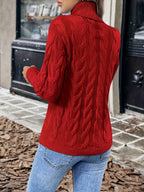 Women's red chunky cable knit turtleneck sweater, back view