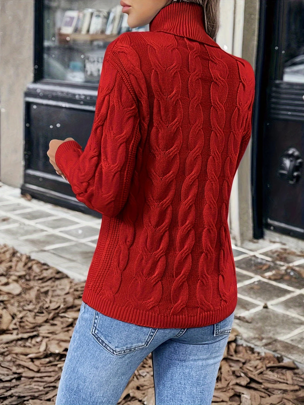 Women's red chunky cable knit turtleneck sweater, back view