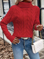 Women's red cable knit turtleneck sweater, styled with handbag