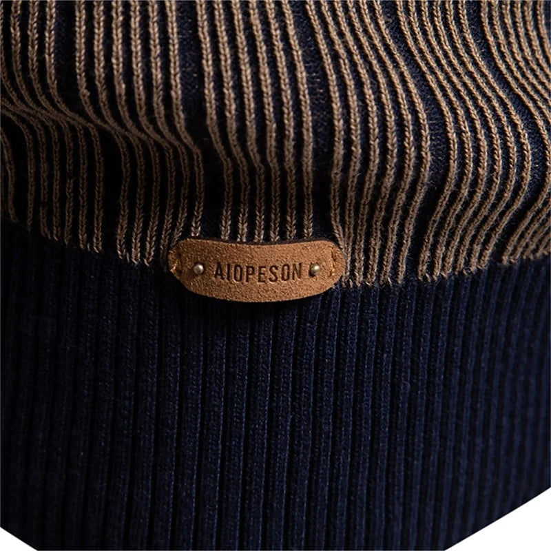 Close-up of leather brand patch on men's mock neck sweater cuff
